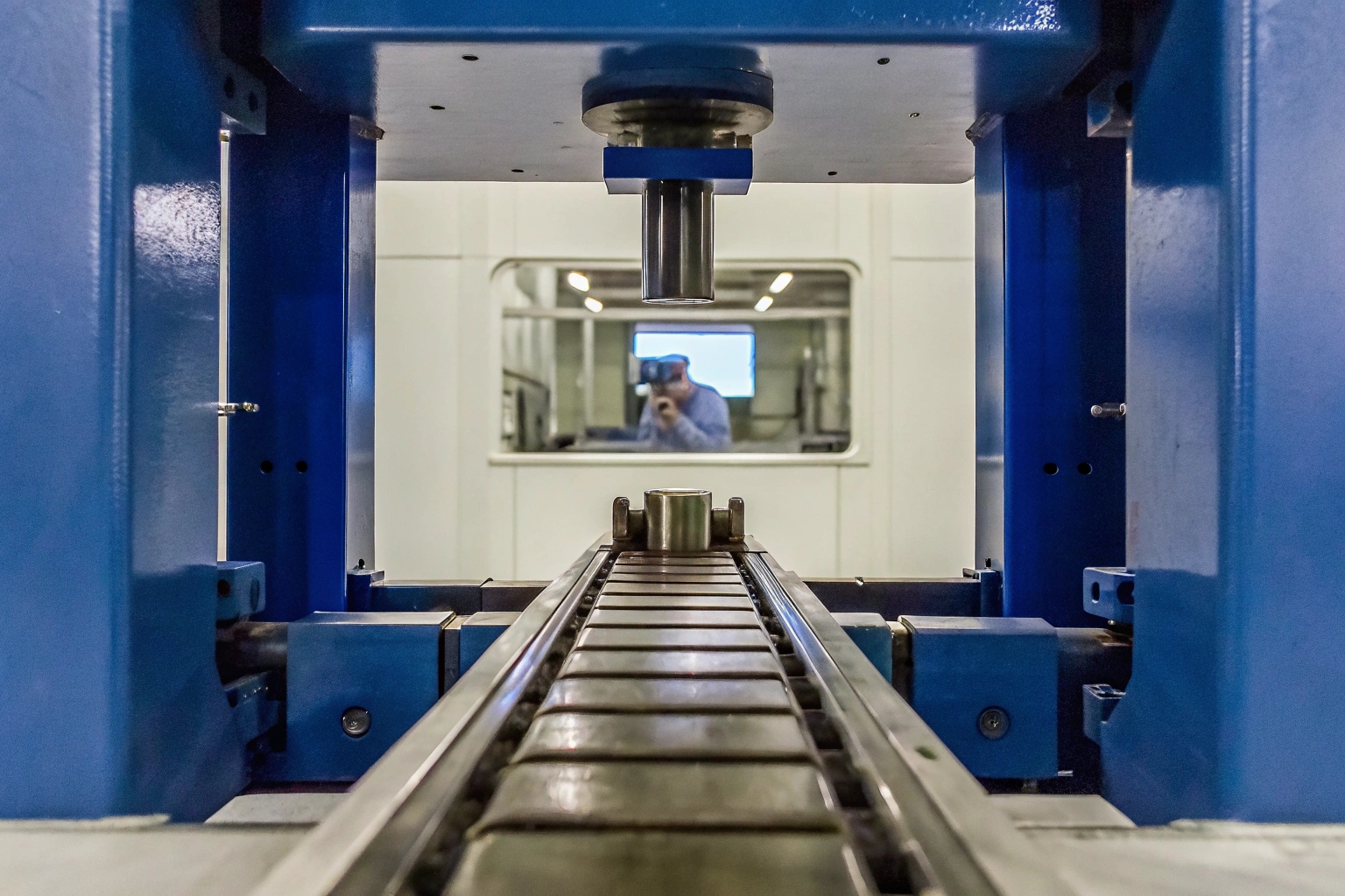 A track shoe component undergoing quality control inspection on an automated factory line.