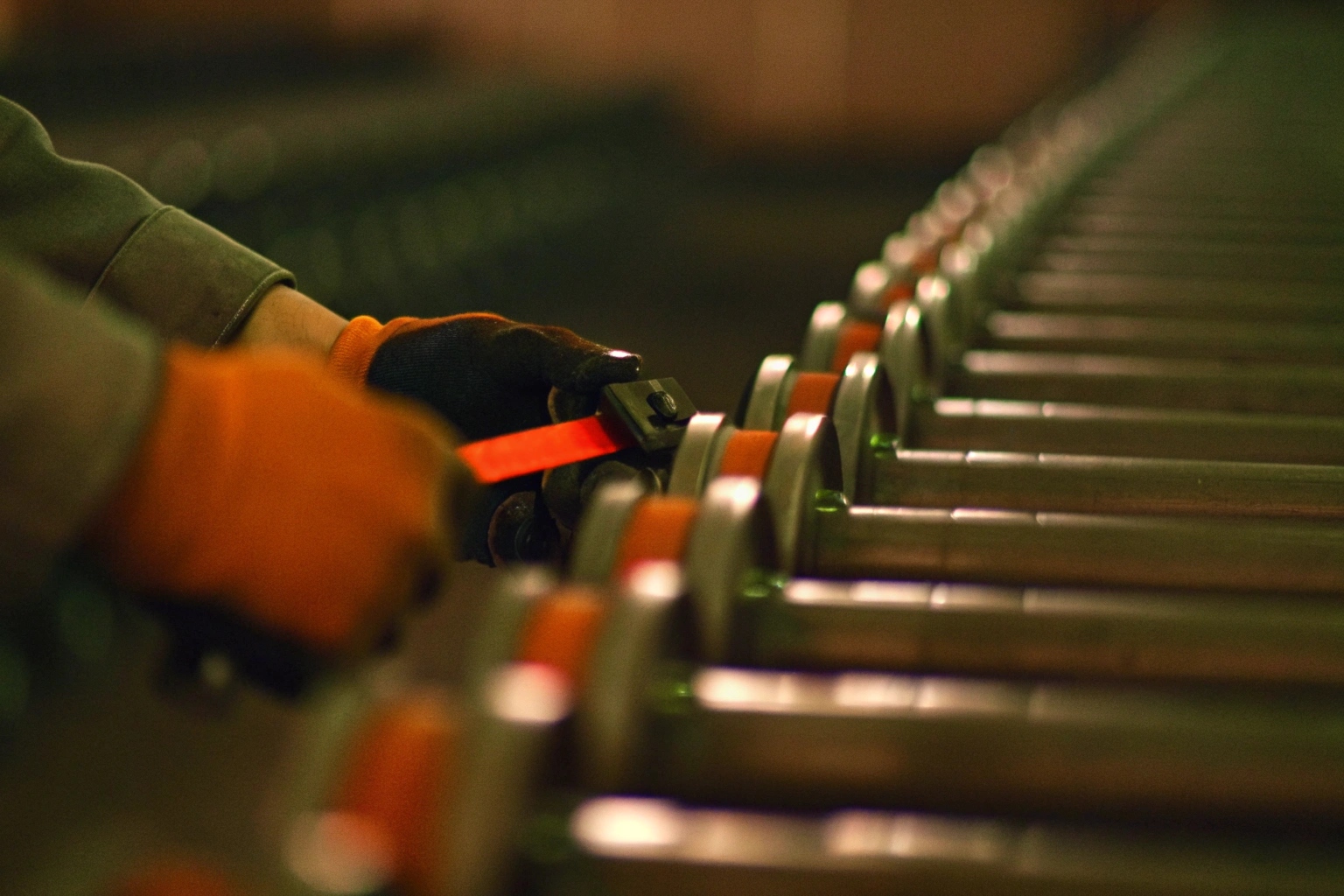 Inspector checking excavator track rollers with calipers